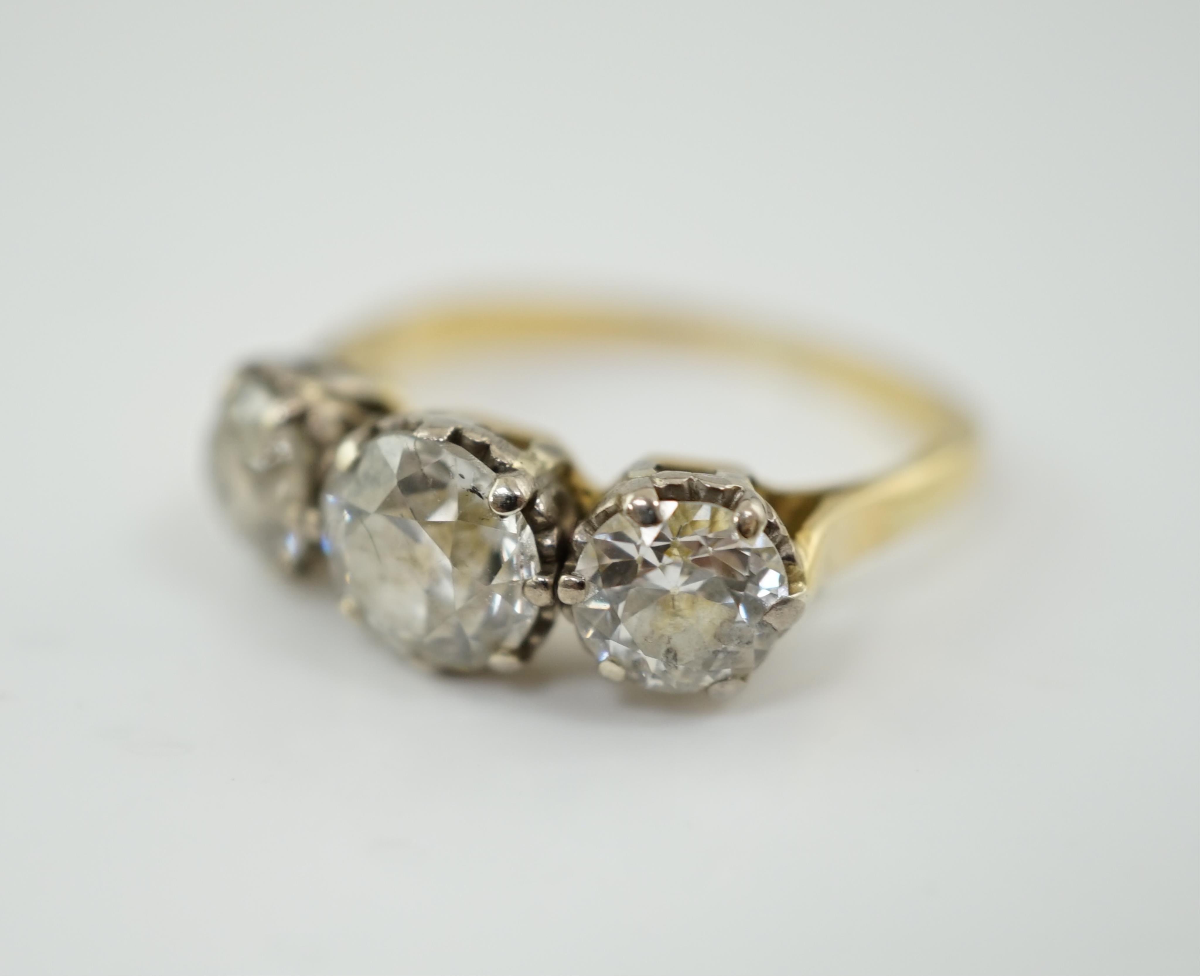 An unmarked gold and three stone diamond set ring